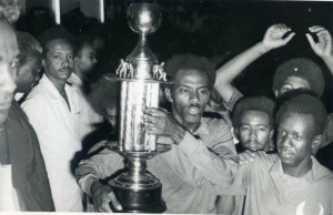 Ali Gagarin con la Coppa d'Africa tra le mani. Presenti in foto anche Jaxa, altra stella del Sudan 1970 (dietro Gagarin), e Shawaaten, uno dei più forti difensori sudanesi di tutti i tempi soprannominato "il Diavolo", sulla destra.